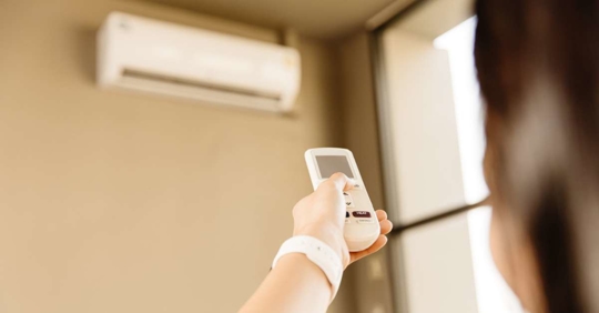 Woman setting the temperature of a ductless mini-split