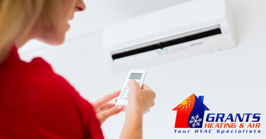 Woman pointing remote at AC unit