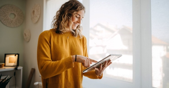Woman near a window, using a tablet
