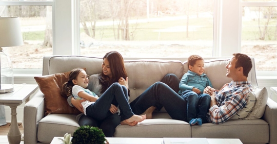 Young family relaxing inside their home